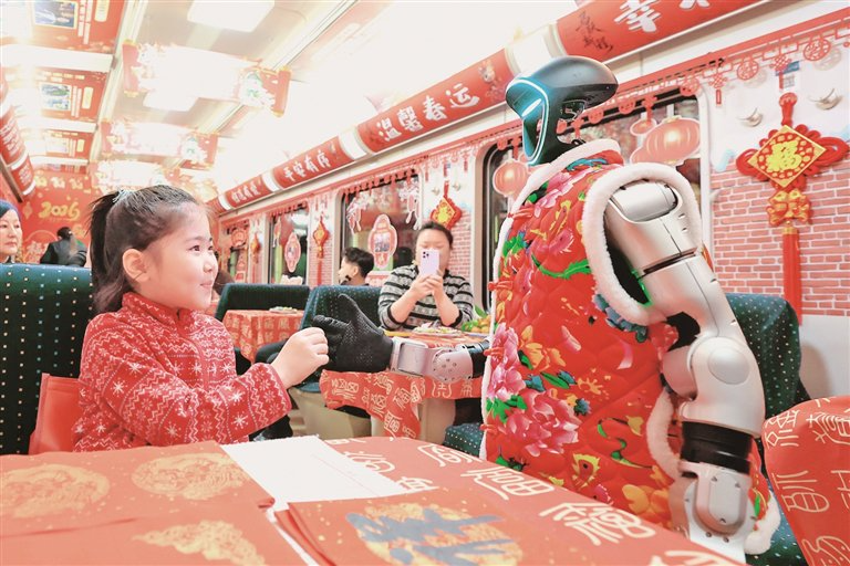 2月13日，小朋友在T48次列车上与仿生机器人握手。贾智摄/光明图片